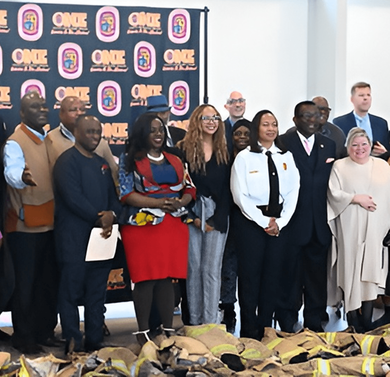 Group of people posing together in front of an event backdrop.